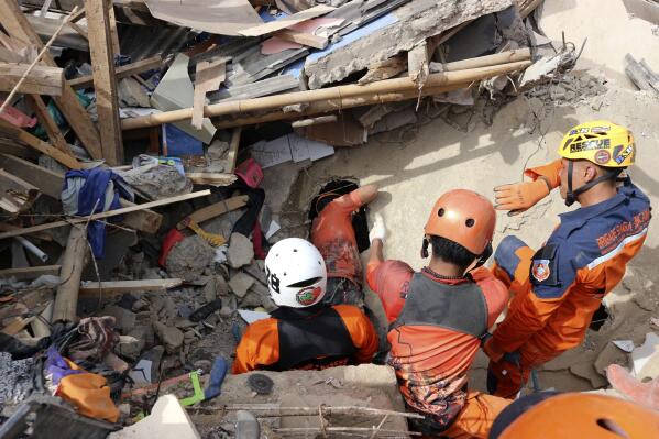 Rescuers search for victims under the rubble of a building collapsed during Monday's earthquake in Cianjur, West Java, Indonesia, Wednesday, Nov. 23, 2022. More rescuers and volunteers were deployed Wednesday in devastated areas on Indonesia's main island of Java to search for the dead and missing from an earthquake that killed hundreds of people. (AP Photo/Rangga Firmansyah)