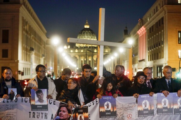 Survivors of sex abuse hold a cross as they gather in front of St. Peter's Square at the Vatican during a vigil prayer for victims of sexual abuse, in Rome, Feb. 21, 2019. (AP Photo/Gregorio Borgia, File)