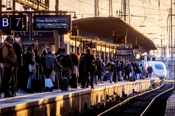 FILE - Passengers wait for a train in the central train station in Frankfurt, Germany, Monday, March 11, 2024. Germany's state-owned main railway operator says that it and a union representing many train drivers have resumed talks in a bitter dispute over working hours and pay. It said Saturday, March 16, 2024 both sides are optimistic that they will achieve a result next week. (AP Photo/Michael Probst, File)