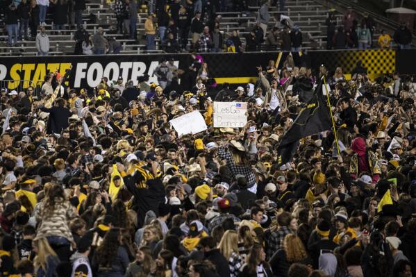 Fans storm the field after Appalachian State defeats Coastal Carolina after an NCAA college football game on Wednesday, Oct. 20, 2021, in Boone, N.C. (AP Photo/Matt Kelley)