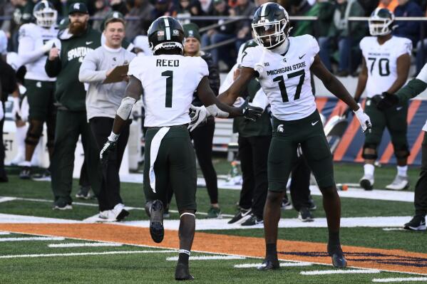 Michigan State wide receiver Tre Mosley (17) high-fives wide receiver Jayden Reed (1) after Reed scored a touchdown against Illinois during the second half of an NCAA college football game, Saturday, Nov. 5, 2022, in Champaign, Ill. (AP Photo/Matt Marton)