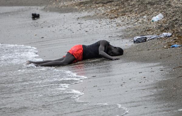 A man lies on the ground on the beach after swimming to the area at the border of Morocco and Spain, at the Spanish enclave of Ceuta, on Tuesday, May 18, 2021. Ceuta, a Spanish city of 85,000 in northern Africa, faces a humanitarian crisis after thousands of Moroccans took advantage of relaxed border control in their country to swim or paddle in inflatable boats into European soil. (AP Photo/Javier Fergo)