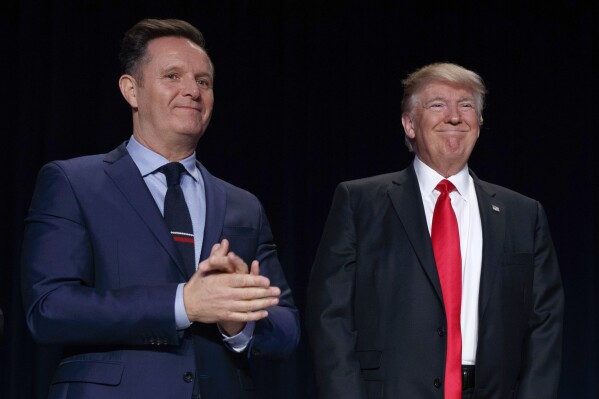 Television producer Mark Burnett, left, looks on as President Donald Trump arrives for the National Prayer Breakfast, Feb. 2, 2017, in Washington. (AP Photo/Evan Vucci, File)