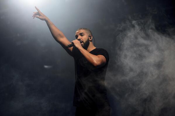 FILE - In this June 27, 2015 file photo, Drake performs on the main stage at Wireless festival in Finsbury Park, London. Drake could have offered Super Bowl week concertgoers just a few songs, but the rapper-singer instead delivered a healthy dose of his hits. The multi-Grammy winner had many jostling for position to watch him perform at “h.wood Homecoming” at the Scottsdale Hangar One on Friday, Feb. 10, 2023. (Photo by Jonathan Short/Invision/AP, File)
