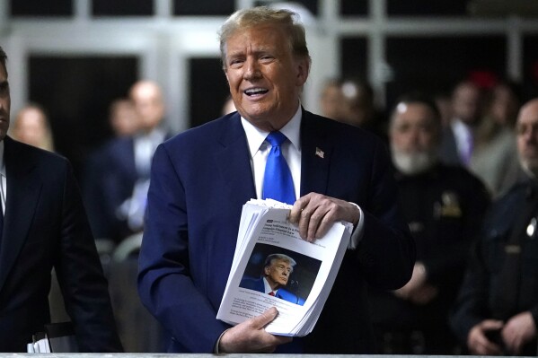 El expresidente Donald Trump sostiene recortes noticiosos mientras habla tras su juicio en un tribunal de lo penal en Manhattan, el jueves 18 de abril de 2024, en Nueva York. (Timothy A. Clary/Foto compartida vía AP)