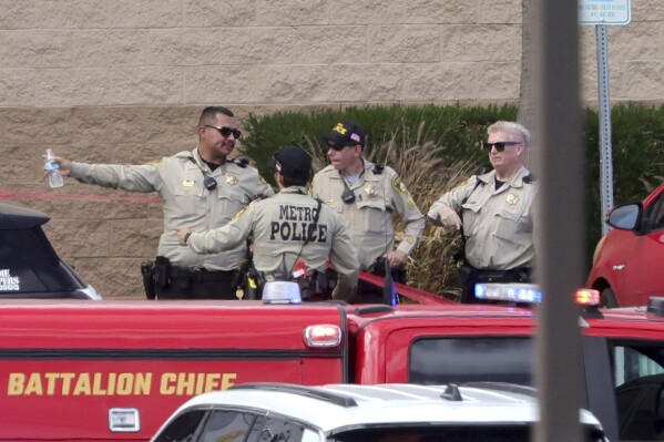 Las Vegas Metro Police officers confer by the main entrance of a Las Vegas Athletic Club after a shooting Friday, May 16, 2025, in Las Vegas. (Steve Marcus/Las Vegas Sun via AP)