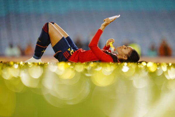 Spain's Salma Paralluelo lies on the ground with her medal at the end of the Women's World Cup soccer final between Spain and England at Stadium Australia in Sydney, Australia, Sunday, Aug. 20, 2023. Spain won 1-0. (AP Photo/Abbie Parr)