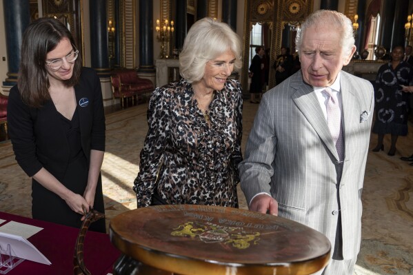 FILE - Britain's King Charles III and Queen Camilla view part of the Royal Collection relating to the Royal family's connection to Kenya, during a reception for the Kenyan diaspora in the UK at Buckingham Palace, central London, Oct. 24, 2023. King Charles III wants to look to the future when his four-day state visit to Kenya starts on Tuesday Oct. 31, 2023. But first he will have to confront the past. (Aaron Chown/Pool via AP, file)
