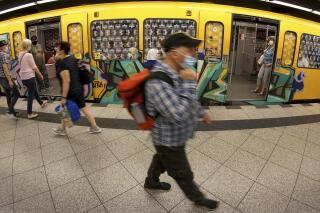 FILE --People wear face masks to protect themself against the coronavirus as they leave and get on board of a subway train in Berlin, Germany, Tuesday, June 23, 2020. Germany's health minister says the country will soon drop a mask mandate in long-distance trains and buses, one of the country’s last remaining COVID-19 restrictions. Rules for local transport are a matter for Germany’s 16 state governments. (AP Photo/Michael Sohn,file)
