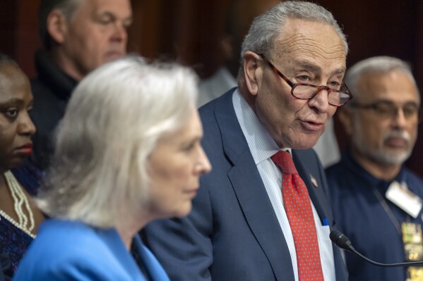 Senate Minority Leader Chuck Schumer, of N.Y., right, speaks as Sen. Kirsten Gillibrand, D-N.Y., left, listens during a news conference to protest cuts in the World Trade Center Health Program on Capitol Hill, Tuesday, May 13, 2025, in Washington. (AP Photo/Mark Schiefelbein)