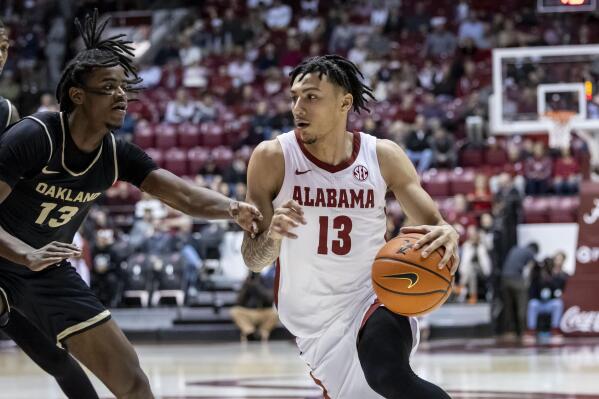 Alabama guard Jahvon Quinerly (13) works the ball around Oakland guard Osei Price (13) during the first half of an NCAA college basketball game, Friday, Nov. 19, 2021, in Tuscaloosa, Ala. (AP Photo/Vasha Hunt)