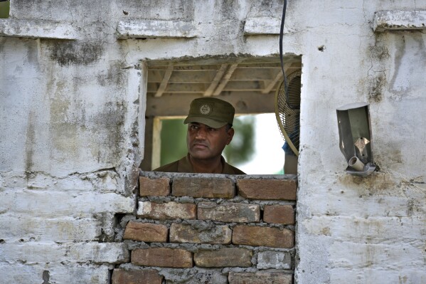 A police officer observes area at a checkpoint on a road leading to the District Jail, in Attock, Pakistan, Wednesday, Aug. 30, 2023. A court asked the official in charge of the Attock prison to keep former Prime Minister Khan there until at least Wednesday, when Khan is expected to face a hearing on charges of 