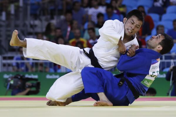 FILE - In this Saturday, Aug. 6, 2016, file photo, Japan's Naohisa Takato, left, competes against Georgia's Amiran Papinashvili during the men's 60-kg judo competition at the 2016 Summer Olympics in Rio de Janeiro, Brazil. “I had enough of the humiliating experience of ending up with a bronze medal in Rio," Takato said. "In the Tokyo Olympics, I’ll definitely seize the gold. With whatever kind of judo, however unrefined that could be, I’ll get a gold medal and play ‘Kimigayo’ (Japan’s national anthem) in the awarding ceremony.” (AP Photo/Markus Schreiber, File)