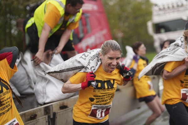Verity Rees from Windermere, Florida, loads up a 20kg sack of coal on her way to winning the women's open category at the World Coal Carrying Championships in Ossett, West Yorkshire, England, Monday, April 21, 2025. (AP Photo/Jon Super)