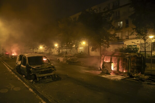 Cars burn on the third night of protests sparked by the fatal police shooting of a 17-year-old driver in the Paris suburb of Nanterre, France, Friday, June 30, 2023. The June 27 shooting of the teen, identified as Nahel, triggered urban violence and stirred up tensions between police and young people in housing projects and other neighborhoods. (AP Photo/Aurelien Morissard)