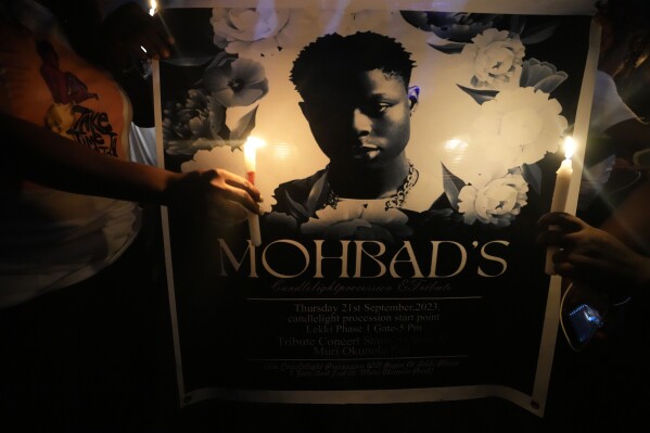 People hold candles during a minute of silence during a protest at a park in Lagos, Nigeria, Thursday, Sept. 21, 2023, to demand justice for Afrobeat star Mohbad following his mysterious death. Thousands marched across Nigeria on Thursday over the mysterious death last week of an Afrobeat star whose body has been exhumed for an autopsy as authorities investigate the cause of his demise. (AP Photo/Sunday Alamba)