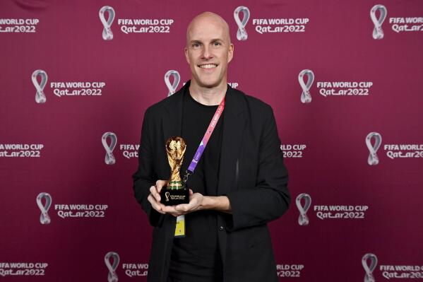 Grant Wahl smiles as he holds a World Cup replica trophy during an award ceremony in Doha, Qatar on Nov. 29, 2022. Wahl, one of the most well-known soccer writers in the United States, died early Saturday Dec. 10, 2022 while covering the World Cup match between Argentina and the Netherlands. (Brendan Moran, FIFA via AP)