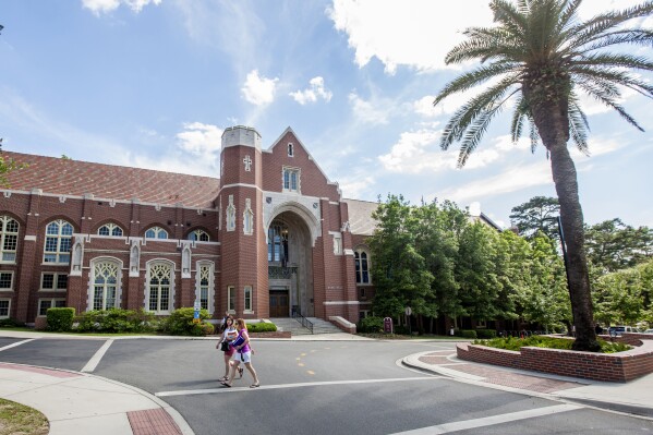 FILE - Students walk past the Dodd Hall on the campus of Florida State University in Tallahassee, Fla., Friday April 30, 2015. A University of Florida research employee and students have been implicated in an illegal, multi-million dollar scheme investigated by the Justice Department to fraudulently buy thousands of biochemical samples of dangerous drugs and toxins that were delivered to a campus laboratory then illicitly shipped to China over seven years. (AP Photo/Mark Wallheiser, file)