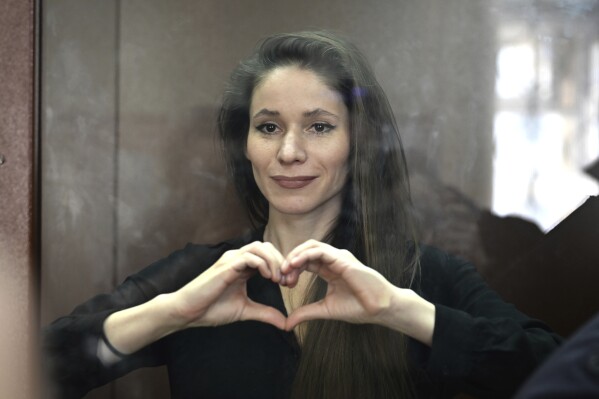 Antonina Favorskaya, accused of working for a group founded by the late Russian opposition politician Alexei Navalny, stands in a defendant's cage in the Basmanny District Court in Moscow, Russia, Friday, March 29, 2024. (AP Photo, File)