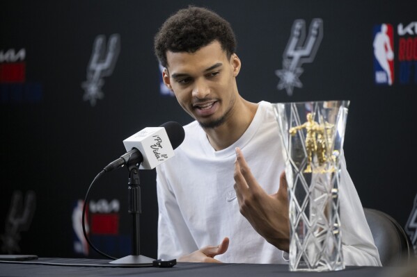 San Antonio Spurs' Victor Wembanyama speaks after receiving his 2023-24 NBA Rookie of the Year trophy during an NBA basketball news conference, Saturday, May 11, 2024, in San Antonio. (AP Photo/Darren Abate)