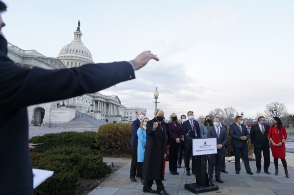 A reporter asks a question of the Problem Solvers Caucus including co-chairs Rep. Tom Reed, R-N.Y., pointing at left, and Rep. Josh Gottheimer, D-N.J., just right of podium, after they spoke to the media about the expected passage of the emergency COVID-19 relief bill, Monday, Dec. 21, 2020, on Capitol Hill in Washington. Congressional leaders have hashed out a massive, year-end catchall bill that combines $900 billion in COVID-19 aid with a $1.4 trillion spending bill and reams of other unfinished legislation on taxes, energy, education and health care. (AP Photo/Jacquelyn Martin)
