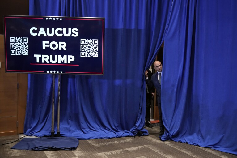 Valet Walt Nauta looks out behind the curtain before Republican presidential candidate former President Donald Trump speaks at a rally at Simpson College in Indianola, Iowa, Sunday, Jan. 14, 2024. (AP Photo/Andrew Harnik)