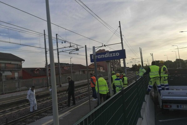 Firefighters inspect the site where five railway workers were killed in Brandizzo, near Turin in northern Italy, Thursday, Aug. 31, 2023, after being hit by a train while carrying out overnight maintenance work. The train, which was transporting wagons on the Milan-Turin line, was traveling at 160km/h (99mph) when it hit the workmen. (LaPresse via AP)