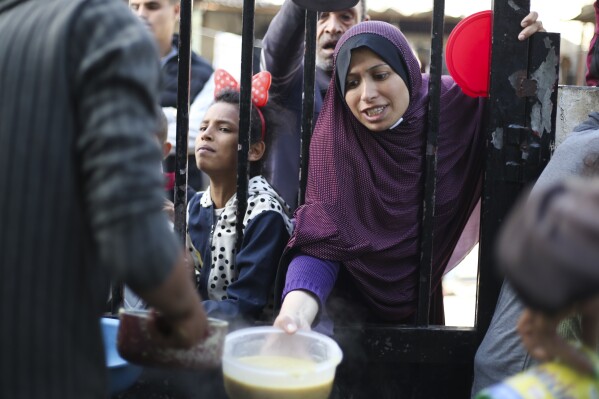 Palestinians line up for a free meal in Rafah, Gaza Strip, Wednesday, Dec. 20, 2023. (AP Photo/Hatem Ali)