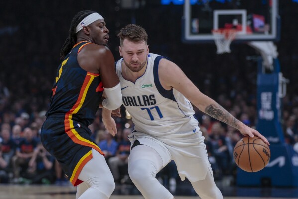 Dallas Mavericks guard Luka Doncic (77) drives against Oklahoma City Thunder guard Luguentz Dort during the first half of Game 5 of an NBA basketball second-round playoff series, Wednesday, May 15, 2024, in Oklahoma City. (AP Photo/Nate Billings)
