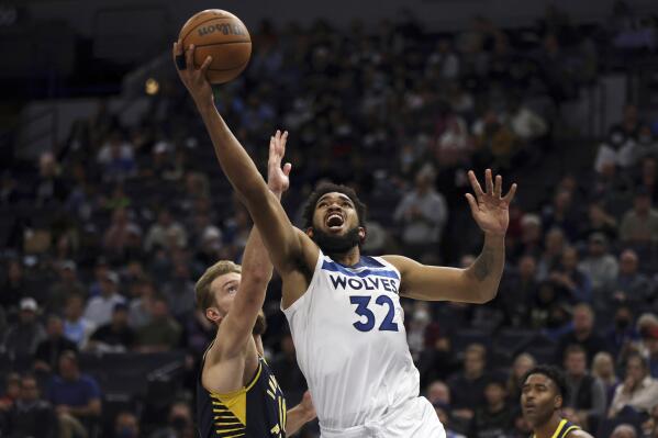 Minnesota Timberwolves center Karl-Anthony Towns (32) shoots the ball against Indiana Pacers forward Domantas Sabonis (11) during the first half of an NBA basketball game Monday, Nov. 29, 2021, in Minneapolis. (AP Photo/Stacy Bengs)