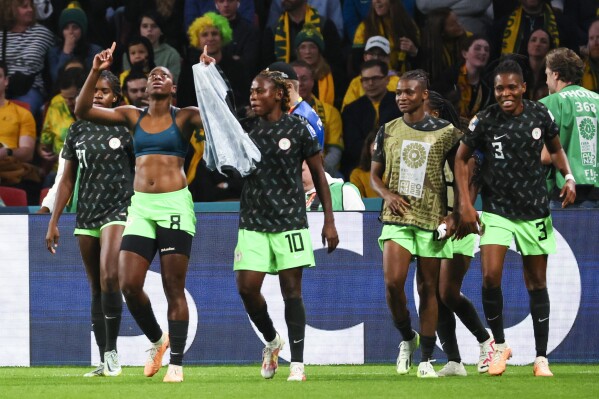 Nigeria's Asisat Oshoala, left, celebrates with teammates after scoring their side's third goal during the Women's World Cup Group B soccer match between Australia and Nigeria In Brisbane, Australia, Thursday, July 27, 2023. (AP Photo/Tertius Pickard)