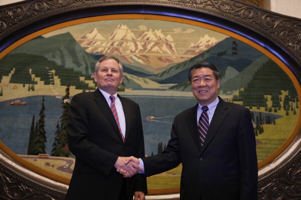 Chinese Vice Premier He Lifeng, right, shakes hands with U.S. Senator Steve Daines before a meeting held in the Xinjiang Room at the Great Hall of the People in Beijing, China, Saturday, March 22, 2025. (AP Photo/Ng Han Guan, Pool)