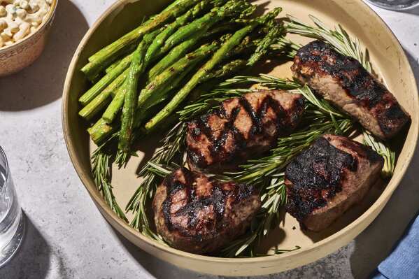 This July 2022, image provided by Cheyenne Cohen shows a grilled top sirloin on a plate with asparagus in New Milford, Conn. (Cheyenne Cohen via AP)