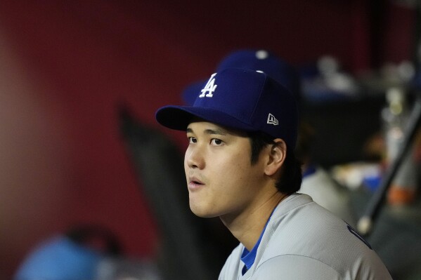 Los Angeles Dodgers' Shohei Ohtani, of Japan, watches the action from the dugout during the second inning of a baseball game against the Arizona Diamondbacks Wednesday, May 1, 2024, in Phoenix. (AP Photo/Ross D. Franklin)