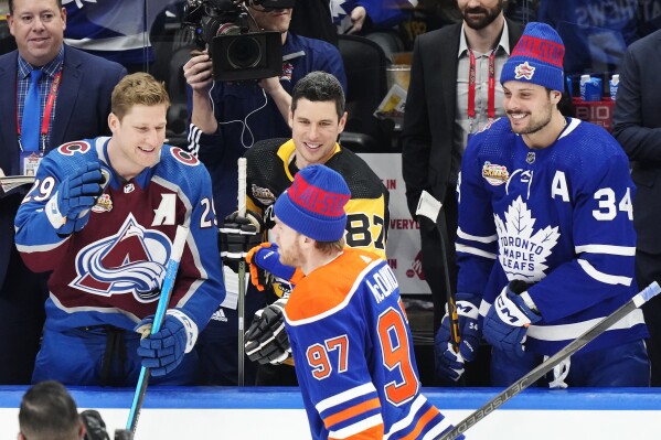 FILE - Edmonton Oilers' Connor McDavid is congratulated by Colorado Avalanche's Nathan MacKinnon, left to right, Pittsburgh Penguins' Sidney Crosby and Toronto Maple Leafs' Auston Matthews after winning the NHL All-Star hockey skills competition in Toronto, Friday, Feb. 2, 2024. Sidney Crosby, Connor McDavid and Nathan MacKinnon have never played together internationally for Canada. Same for Auston Matthews, Jack Eichel and Matthew Tkachuk with the U.S. That is finally set to change next year at the 4 Nations Face-Off, an international tournament precursor to the 2026 Milan Olympics that marks the return of NHL players to that world stage.(Frank Gunn/The Canadian Press via AP, File)