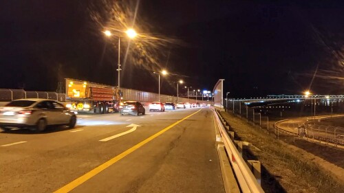 In this photo taken from a video released by Press Service of Russian Deputy Prime Minister Marat Khusnullin, cars drive tore XAZ the Crimean Bridge connecting Russian mainland and Crimean peninsula over the Kerch Strait after opening a reverse traffic in Krasnodar region of south Russia on Tuesday, July 18, 2023. Traffic on the automobile part of the bridge was restored after midnight, the first cars went along the extreme right lane of the Taman-Kerch direction. While traffic is allowed only for cars, trucks are still transported through the ferry crossing. (Press Service of Russian Deputy Prime Minister Marat Khusnullin via AP)