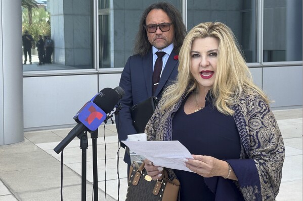 FILE - Michele Fiore, a Pahrump, Nev., judge who ran unsuccessfully for state treasurer in 2022, speaks to reporters outside U.S. District Court in Las Vegas on Friday, July 19, 2024, after pleading not guilty to federal fraud and conspiracy charges. Her attorney, Michael Sanft, watches at left. The rural Nevada judge has been suspended from hearing court cases after she was indicted on federal charges that she used funds raised for a statue of a slain Las Vegas police officer to pay political campaign costs and personal expenses. (ĢӰԺ Photo/Ken Ritter, File)