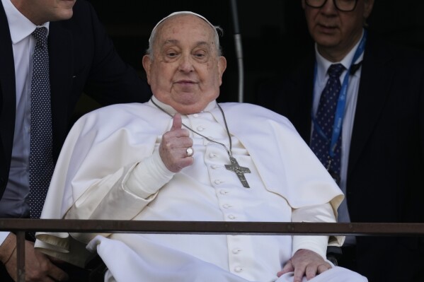Pope Francis thumbs up as he appears at a window of the Agostino Gemelli Polyclinic in Rome, Sunday, March 23, 2025, where he has been treated for bronchitis and bilateral pneumonia since Feb. 14. (AP Photo/Domenico Stinellis)