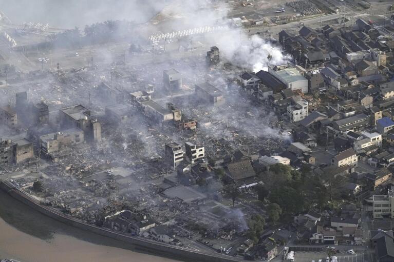 Smoke rises from the site of a fire occurred following an earthquake in Wajima, Ishikawa prefecture, Japan Tuesday, Jan. 2, 2024. (Kyodo News via AP)
