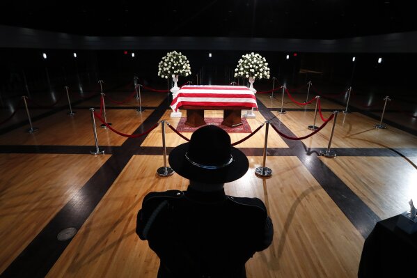 
              A police officer stands guard stands guard at the casket of former Michigan Rep. John Dingell, lying in repose in Dearborn, Mich., Monday, Feb. 11, 2019. Dingell, the longest-serving member of Congress in American history, was first elected in 1955 and retired in 2014. The Democrat was 92. (AP Photo/Paul Sancya)
            
