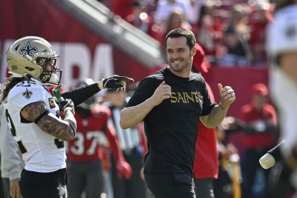 Inactive New Orleans Saints quarterback Derek Carr walks on the field up before an NFL football game against the Tampa Bay Buccaneers Sunday, Jan. 5, 2025, in Tampa, Fla. (AP Photo/Jason Behnken)