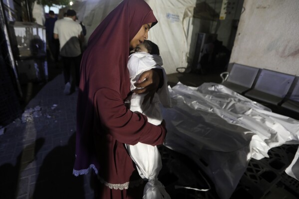 A Palestinian woman mourns her relative, 7-month old baby Hani Qeshta, who was killed in an Israeli bombardment on a residential building with Qeshta's family, at the morgue of Al Najjar hospital in Rafah, southern Gaza Strip, Sunday, May 5, 2024. (AP Photo/Ismael Abu Dayyah)