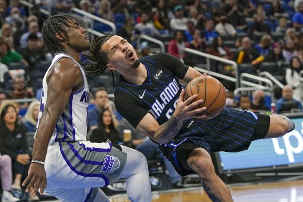 Orlando Magic guard Cole Anthony, right, is fouled by Sacramento Kings guard Davion Mitchell as he goes in to shoot during the second half of an NBA basketball game, Saturday, March 26, 2022, in Orlando, Fla. (AP Photo/John Raoux)