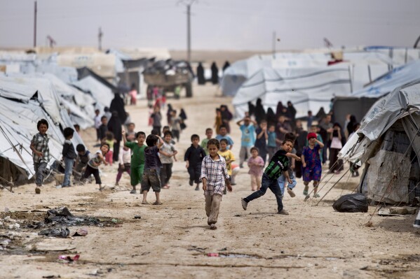 FILE - Children gather outside their tents at the al-Hol camp, which houses families of members of the Islamic State group, in Hasakeh province, Syria, on May 1, 2021. Iraq is stepping up repatriation of its citizens from a camp in northeastern Syria housing tens of thousands of people, mostly wives and children of Islamic State fighters but also supporters of the militant group. It’s a move that Baghdad hopes will reduce cross-border militant threats and eventually lead to shutting down the facility. (AP Photo/Baderkhan Ahmad, File)