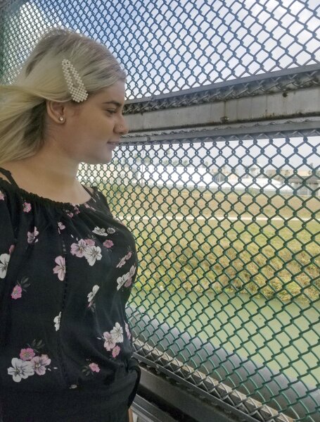 In this Monday, Feb. 17, 2020 photo provided by attorney Jodi Goodwin, a Venezuelan teenager named Branyerly stands on an international bridge connecting Brownsville, Texas, and Matamoros, Mexico, ...