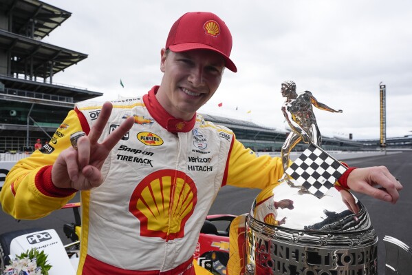 Josef Newgarden poses with the Borg-Warner Trophy during the traditional winners photo session at Indianapolis Motor Speedway, Monday, May 27, 2024, in Indianapolis. Newgarden won the 108th running of the Indianapolis 500 auto race Sunday. (AP Photo/Darron Cummings)