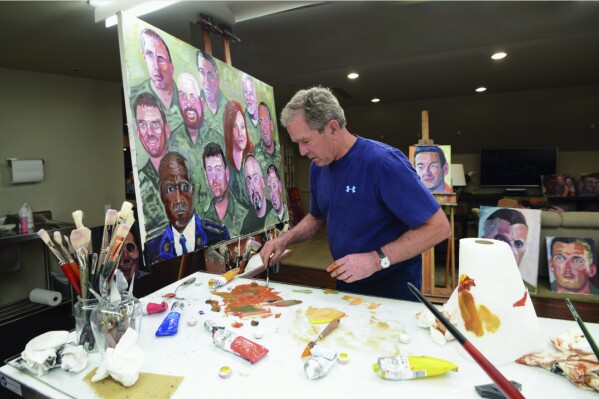 This photo provided by the George W. Bush Presidential Center shows former President George W. Bush working on a portrait of service members and veterans. The George W. Bush Institute is loaning the 60 color portraits by the former U.S. president to Walt Disney World. The paintings of service members and veterans will be on display for a year starting next month at Epcot's American Adventure pavilion. (Courtesy of the George W. Bush Presidential Center via AP)