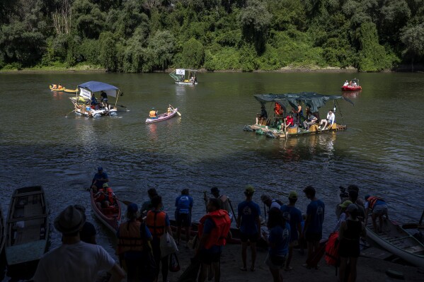 Volunteers set on the Tisza River on their canoes and boats as they participate in Plastic Cup event near Tiszaroff, where they scour Hungary's second-largest river for trash on Tuesday, Aug. 1, 2023. (AP Photo/Denes Erdos)