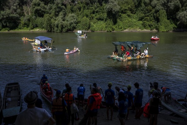 Volunteers offload their boat after it overloaded with collection bags  while attending the Plastic Cup event near Tiszaroff, Hungary, on Aug. 2,  2023. Since its start in 2013, participants in the annual