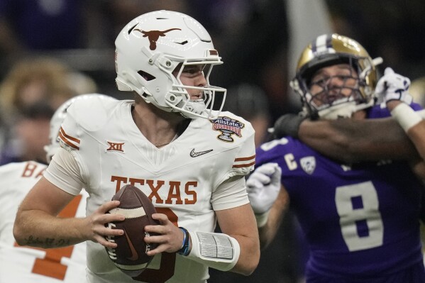 Texas quarterback Quinn Ewers (3) moves out of the pocket against Washington during the first half of the Sugar Bowl CFP NCAA semifinal college football game, Monday, Jan. 1, 2024, in New Orleans. (AP Photo/Gerald Herbert)